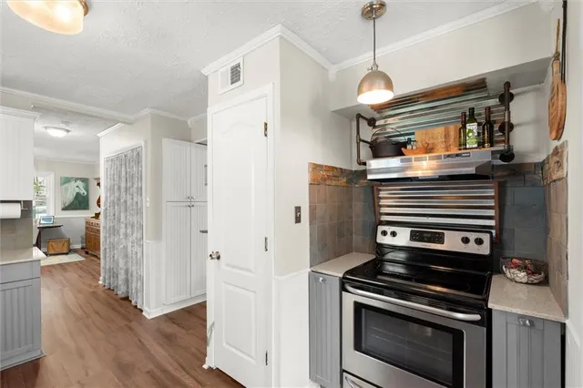 a kitchen with wooden floor and a stove top oven