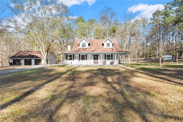 a front view of residential houses with yard and trees