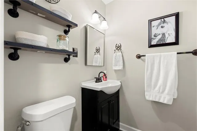 a bathroom with a sink vanity mirror and toilet