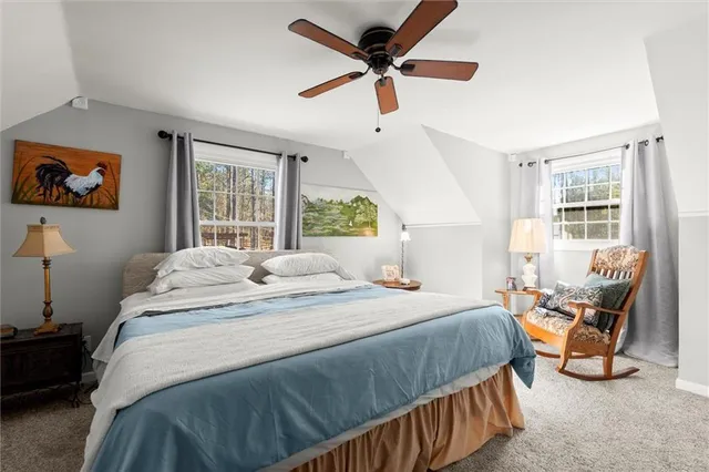 a bedroom with a bed a couch and a large window