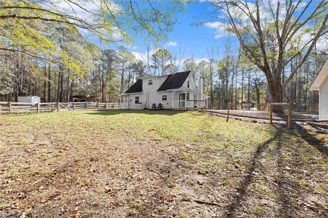 a view of a house with a yard and tree s