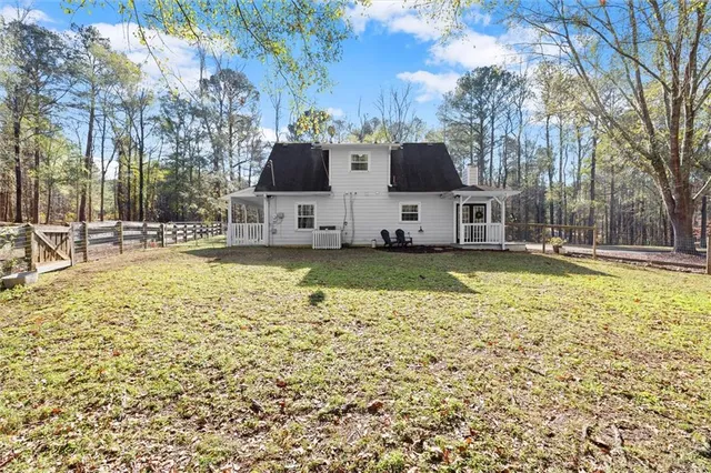 a view of a white house with a yard and sitting area