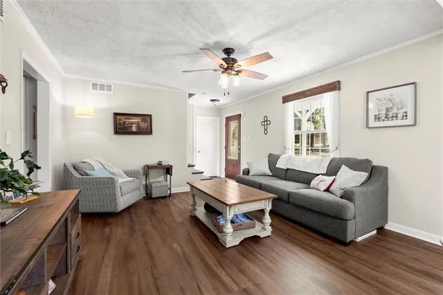 a living room with furniture and a wooden floor