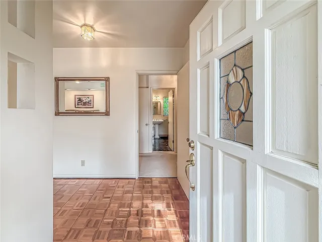 a dining room with wooden floor a chandelier fan a wooden table and chairs