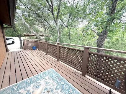 a view of balcony with wooden floor and fence
