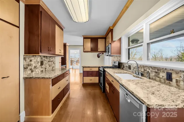 a kitchen with granite countertop a sink stove and cabinets