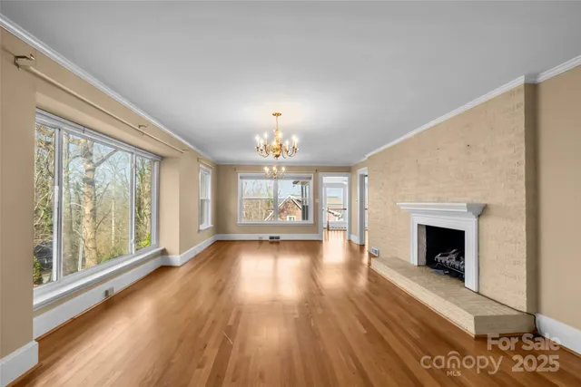 wooden floor fireplace and windows in an empty room