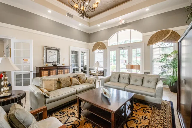 a living room with furniture a large window and a dining table