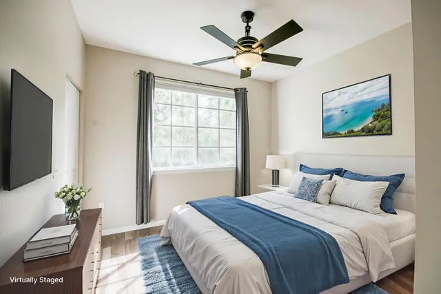 a bedroom with a large bed chandelier and a window