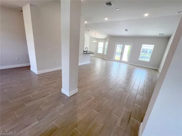 a view of empty room with wooden floor
