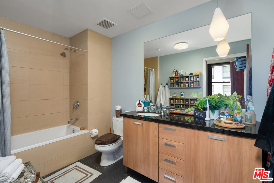460 South Spring Street, Unit 813 Los Angeles, CA 90013 - Photo 14 of 26 a bathroom with a double vanity sink toilet mirror and bathtub