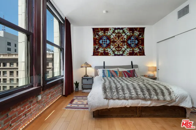 a bedroom with a bed and a large window