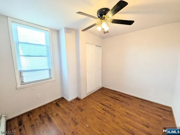 an empty room with a window and a fan