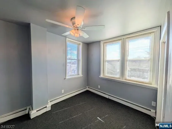 an empty room with a window and a fan