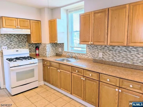 a kitchen with stainless steel appliances a stove sink and cabinets