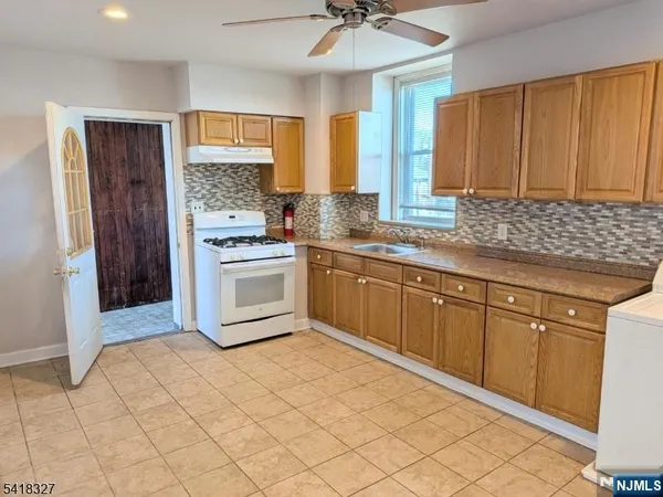 a kitchen with stainless steel appliances granite countertop a stove a sink and a refrigerator