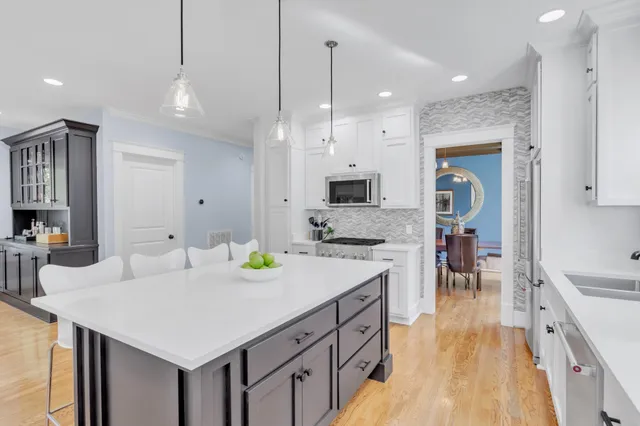 a kitchen with stainless steel appliances granite countertop a stove a sink and a microwave