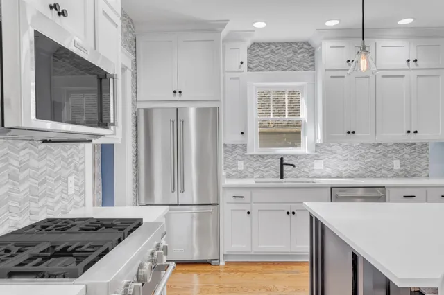 a large kitchen with kitchen island a sink counter space appliances and a living room view