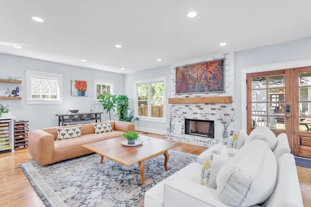 a living room with fireplace furniture and a large window