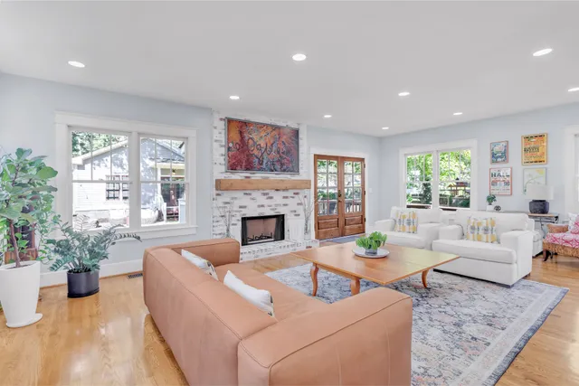 a living room with furniture kitchen view and a large window