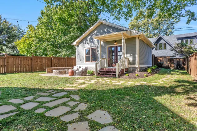 a view of a house with a patio and a wooden fence