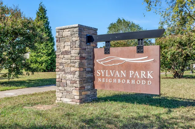a view of a park with plants and large trees