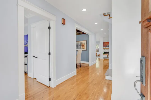 a view of a hallway with wooden floor and windows