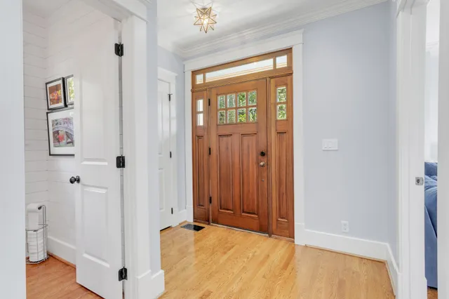 a view of a hallway with wooden floor and closet