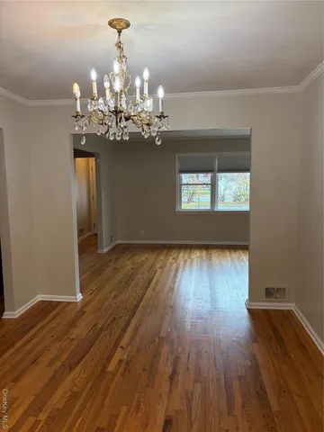a view of a room with wooden floor and chandelier
