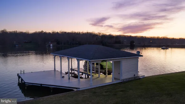 a kitchen with stainless steel appliances granite countertop a refrigerator a stove a sink a dining table and chairs with wooden floor