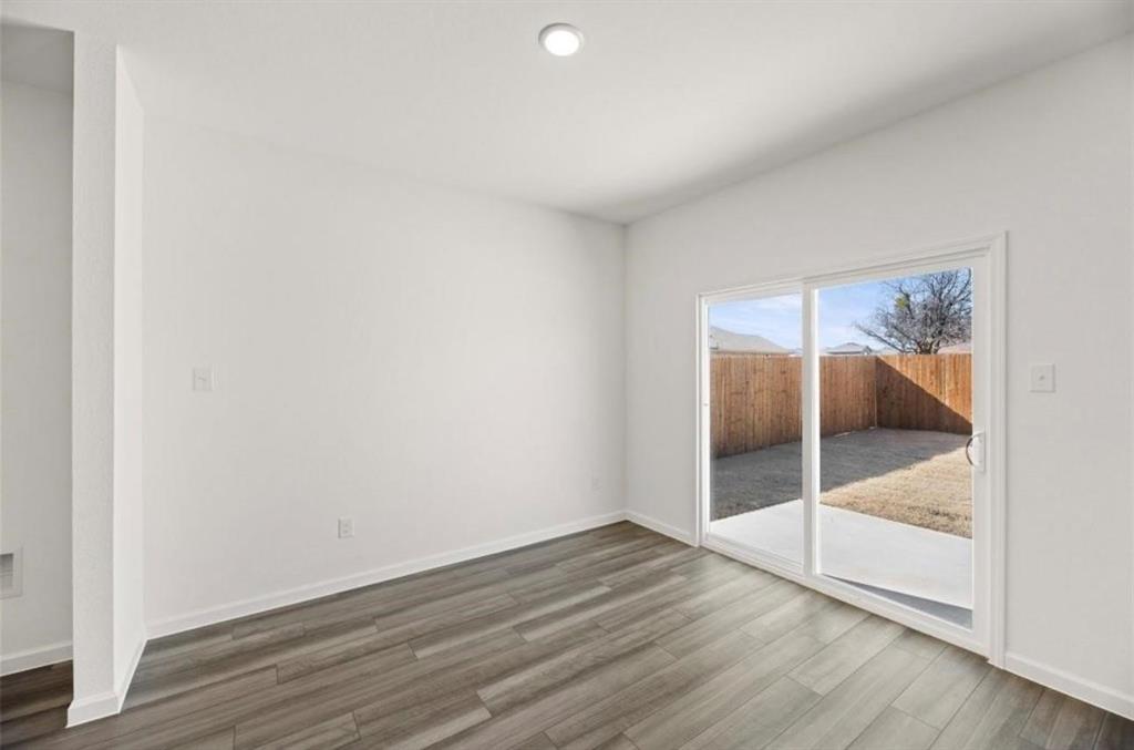 10308 Holy Cross Lane Crowley, TX 76036 - Photo 13 of 27 an empty room with wooden floor and glass door