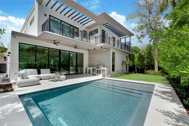 a view of a house with backyard and sitting area