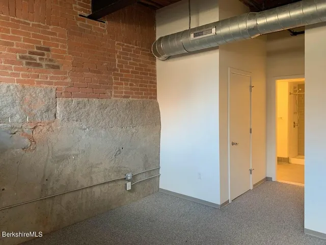a view of a hallway with wooden shelves