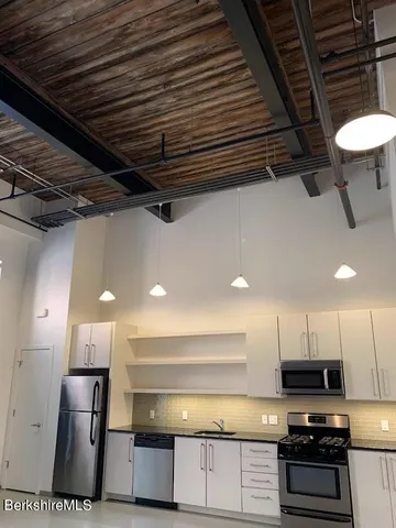 a kitchen with stainless steel appliances a refrigerator and a stove