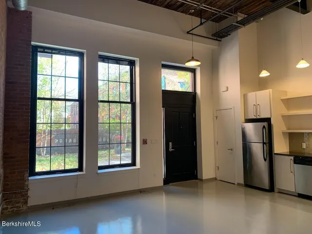 a view of an empty room with a kitchen