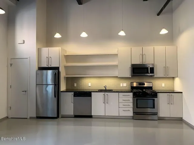 a kitchen with kitchen island a sink and stainless steel appliances