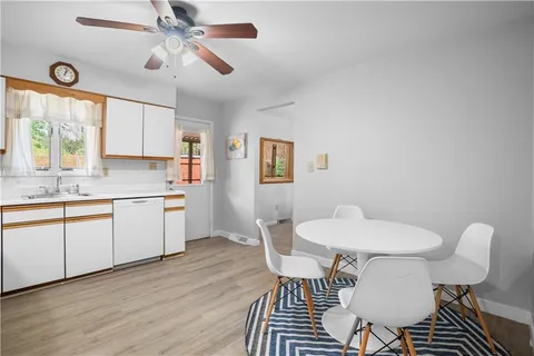 a kitchen with a dining table chairs and white cabinets