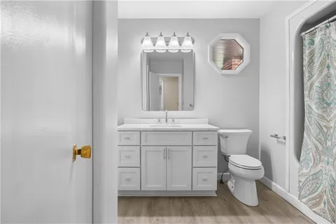 a bathroom with a sink a toilet and a mirror