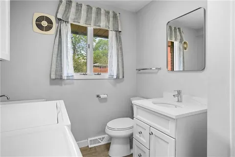 a bathroom with a sink a toilet and a mirror