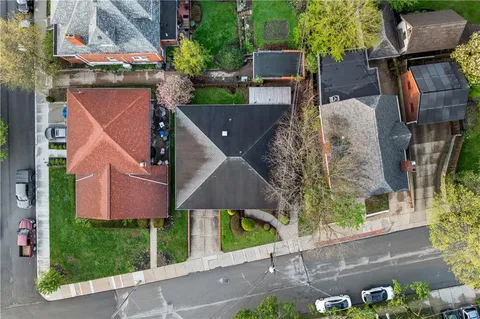 an aerial view of residential houses with outdoor space and trees