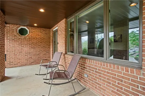 a view of a patio with a table and chairs and floor to ceiling window