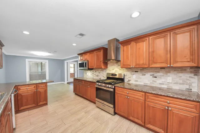 a kitchen with granite countertop wooden cabinets a sink and dishwasher