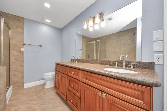 a bathroom with a granite countertop sink a large mirror and a window