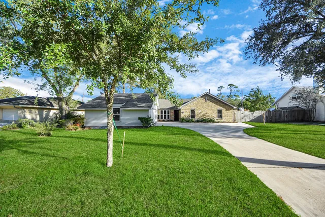 a front view of a house with a yard and tree