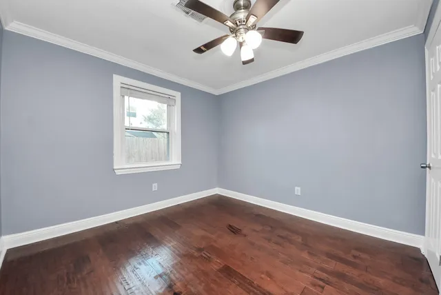 a view of an empty room with wooden floor