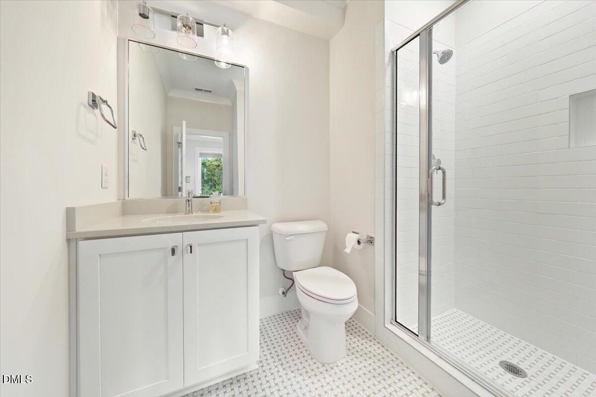 712 East Edenton Street, Unit 102 Raleigh, NC 27601 - Photo 6 of 17 a bathroom with a toilet a sink and a mirror