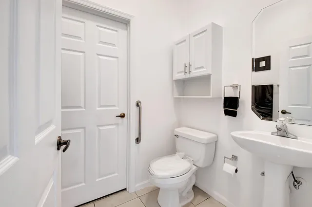 a bathroom with a toilet sink and mirror