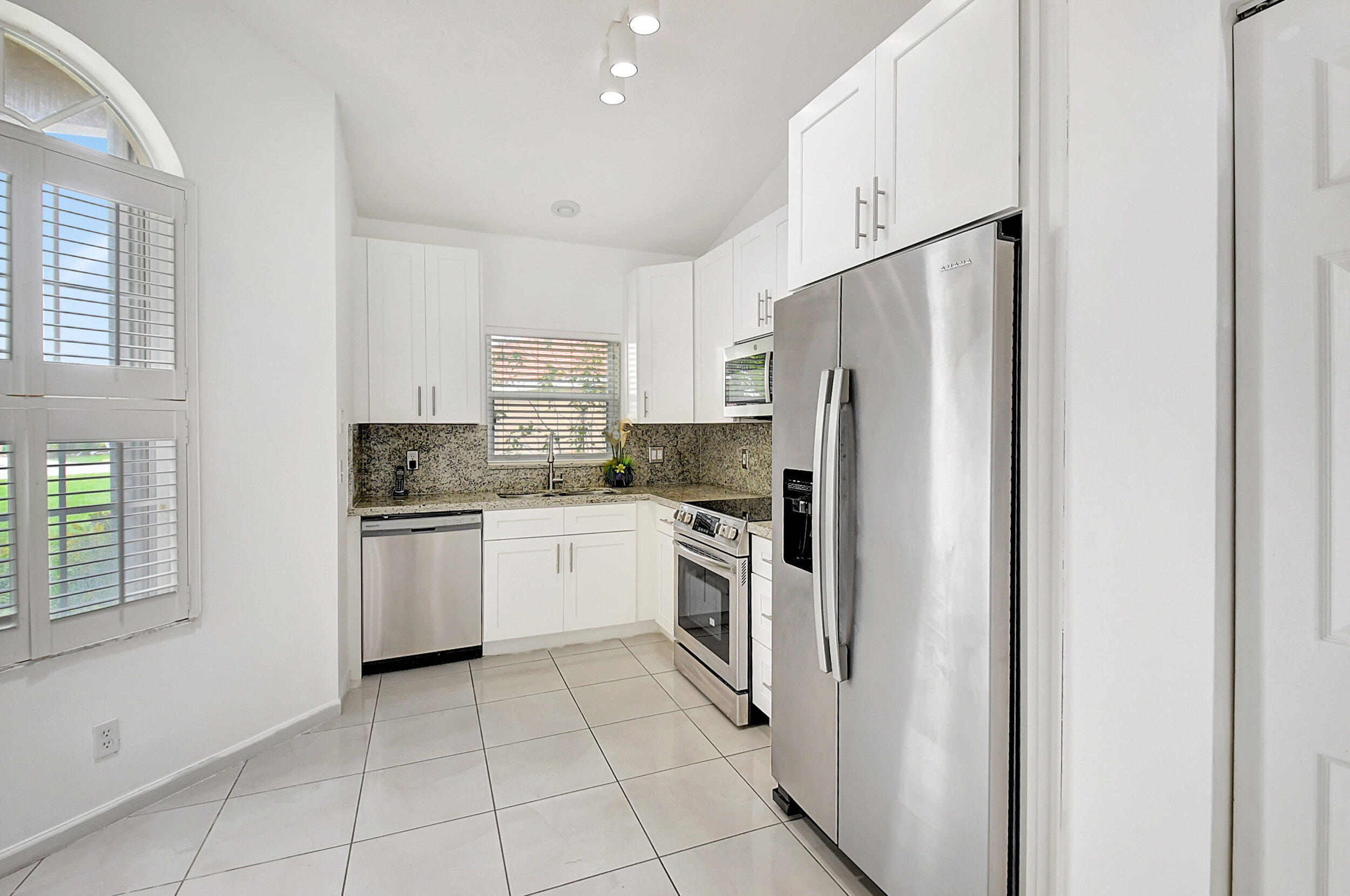 6340 Long Key Lane Boynton Beach, FL 33472 - Photo 3 of 29 a kitchen with a refrigerator sink and cabinets