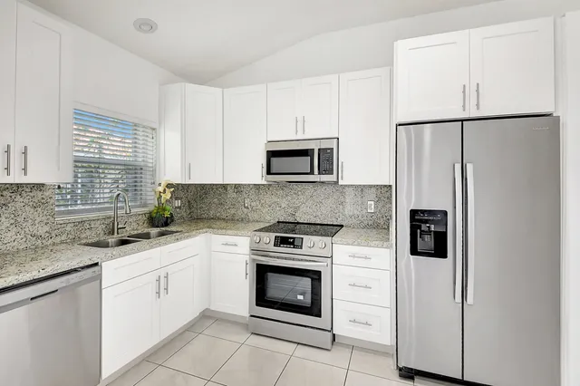 a kitchen with white cabinets and white appliances