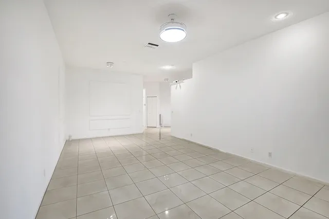 an empty room with white walls and tiles